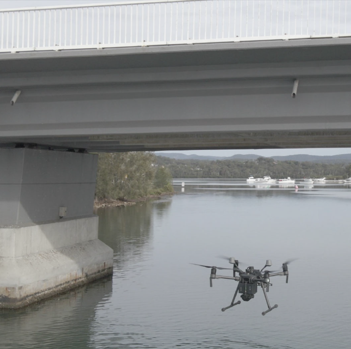 drone flying towards a bridge