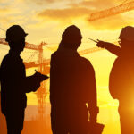 Engineers survey industrial site at sunset