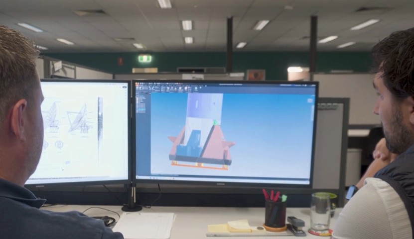 Engineering drafter working on a 3D model at a workstation